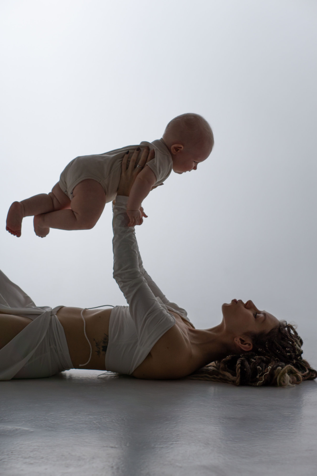 A mother holding her swaddled newborn close in warm light